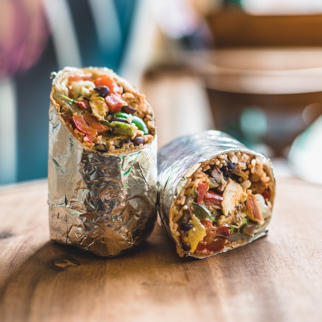 A burrito cut in half on a wooden board, commercial food photography by Ryan Stanikk for Mexigo Southampton
