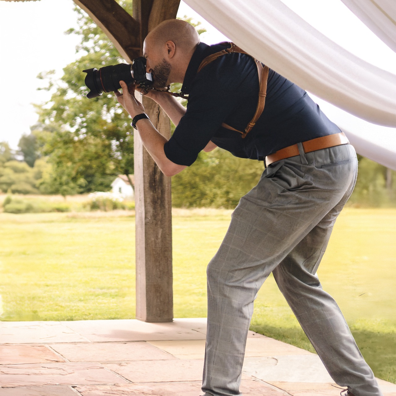 Ryan Stanikk photographing a wedding in Somerset with a professional camera and leather harness strap