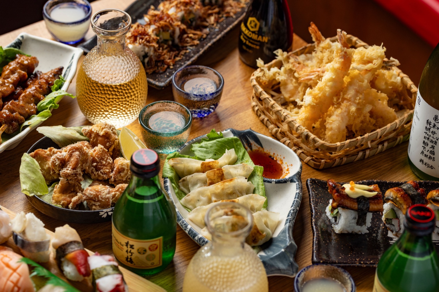 Japanese sharing spread at Sakura Southampton with nigiri and maki sushi, gyoza, karaage fried chicken, prawn tempura, yakitori skewers and carafes of sake, food photography by Ryan Stanikk