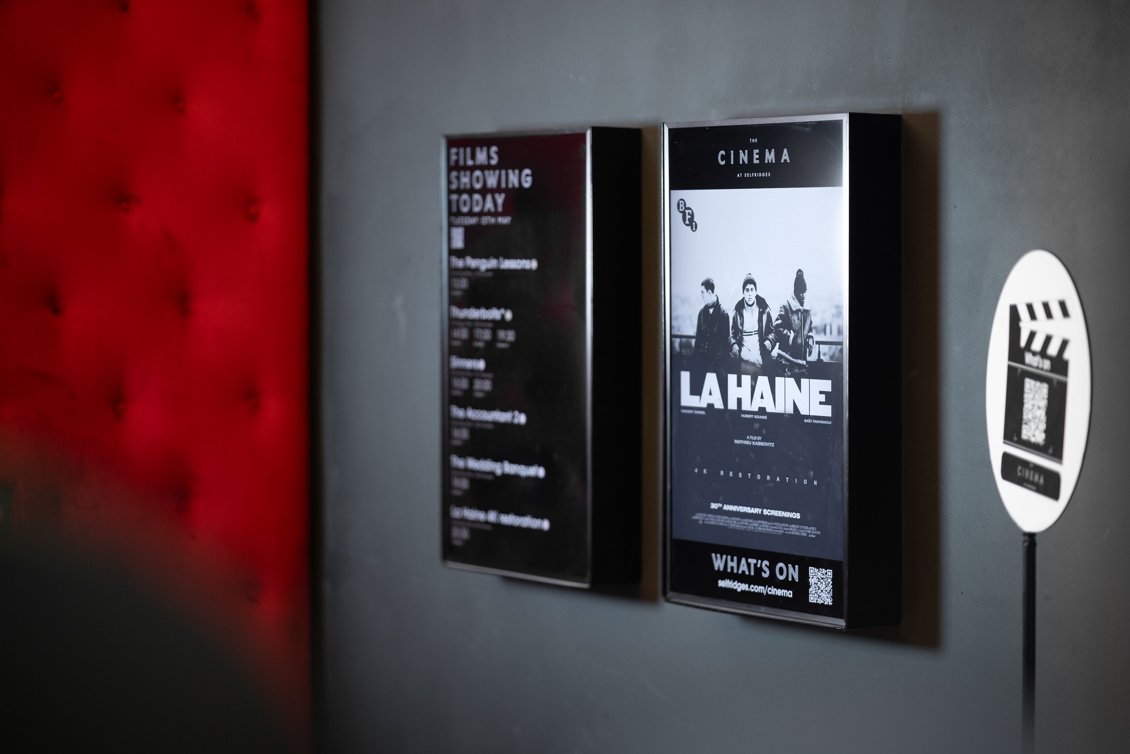 Digital screens displayed inside an indoor cinema space at Selfridges, lit with a softbox to balance the warm tungsten ambient bulbs and avoid reflections, commercial interior photography
