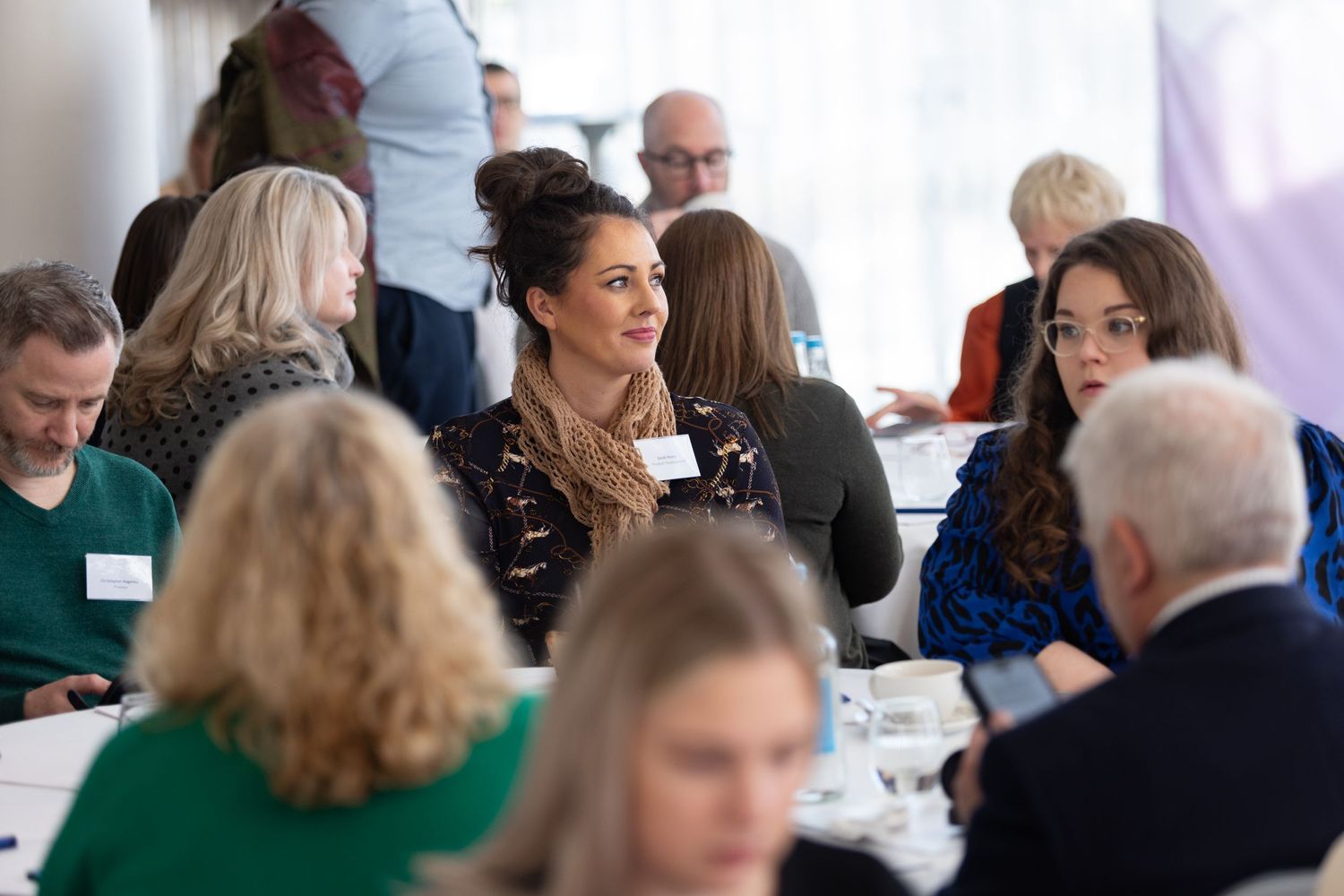 Delegates seated at tables during a corporate conference session, business event photography