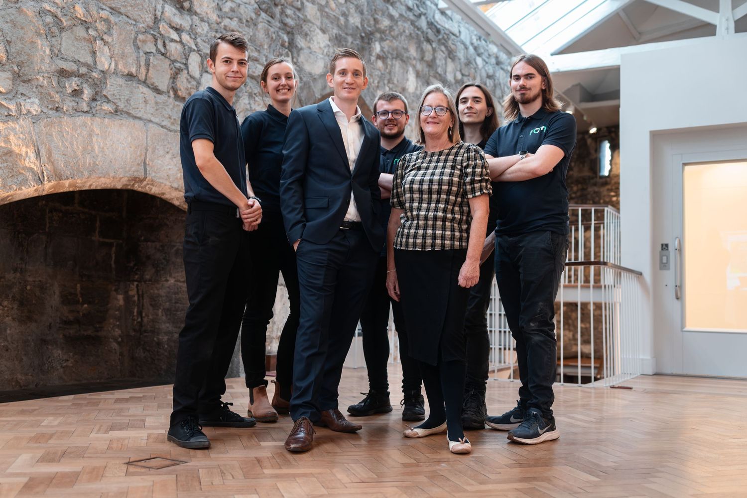 Team posing for a group photo in a stone-walled venue, corporate team photography Southampton