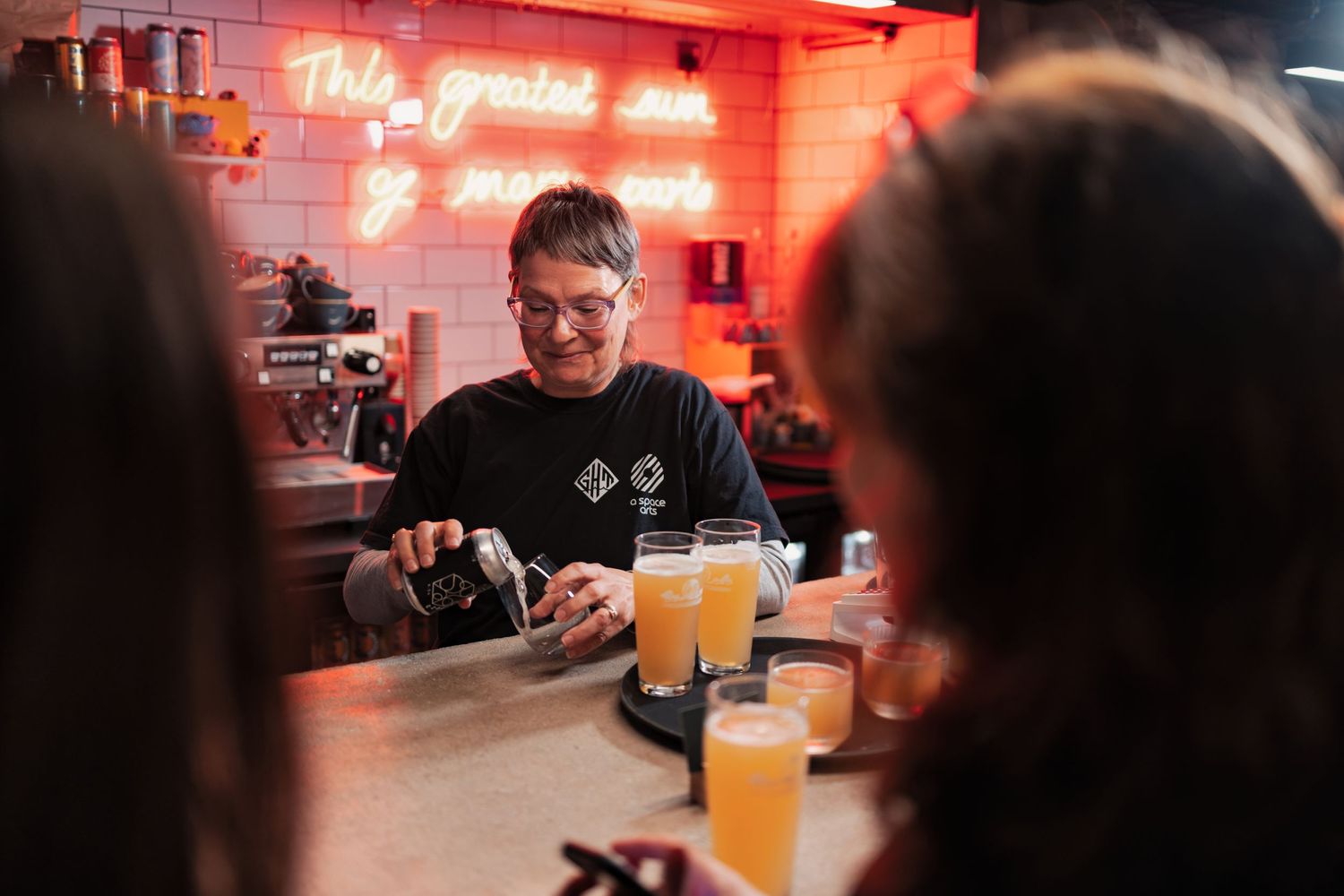 Bartender pouring craft beer at a bar with neon signage at a corporate networking event, corporate event photography Southampton
