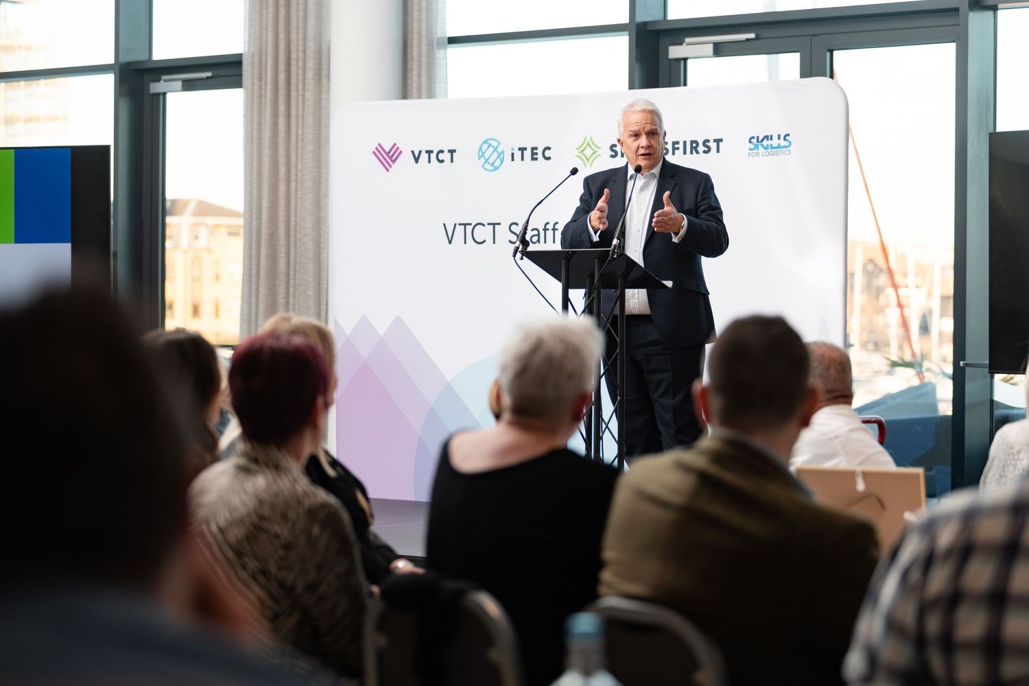 Speaker at a podium addressing staff at the VTCT Staff Conference Awards 2024, Harbour Hotel Southampton, corporate event photography