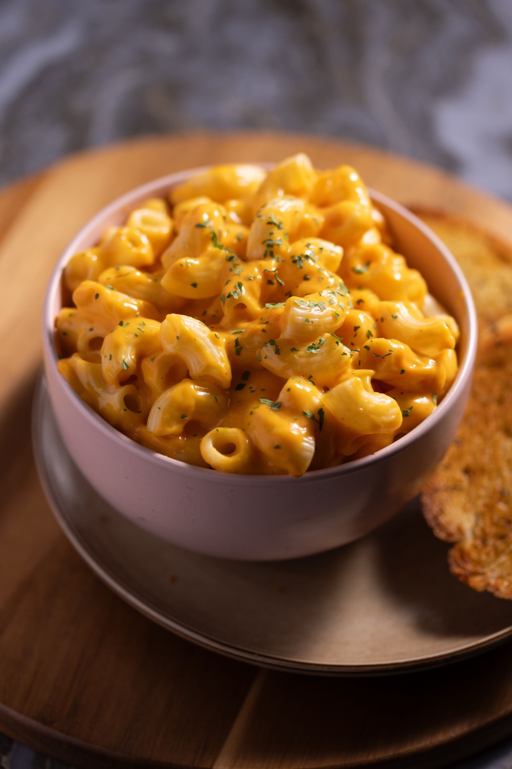Mac and cheese in a bowl with garlic bread on a wooden board at Barga Eastleigh, comfort food photography
