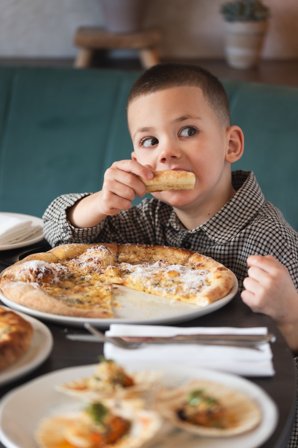 Young boy eating garlic bread with a cheese pizza at Figurati Italian restaurant Southampton, family dining lifestyle photography