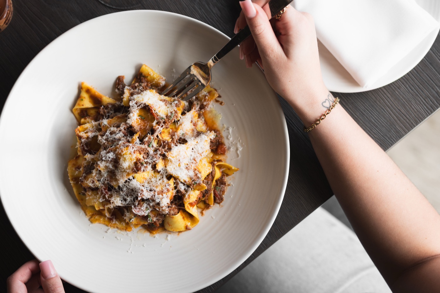 Pappardelle pasta with slow-cooked ragu and parmesan being twirled on a fork at Figurati Italian restaurant Southampton, food photography