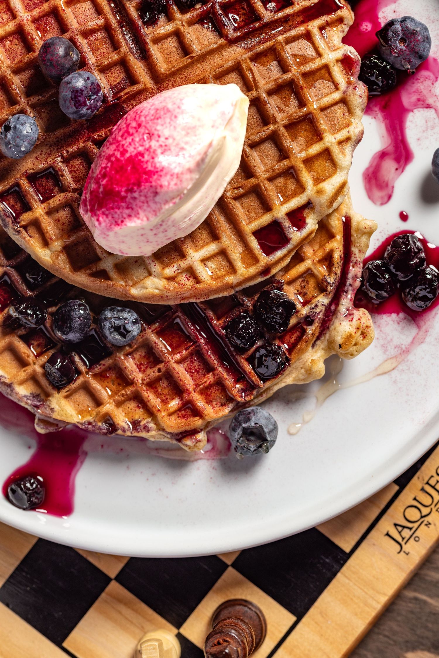 Stacked Belgian waffles with blueberries, berry compote and a quenelle of cream at Room2 cafe, brunch menu food photography Southampton