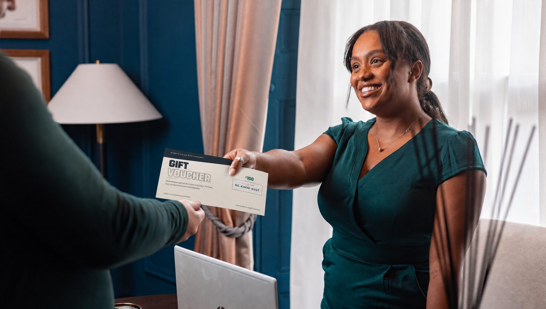 A smiling recipient being handed a Ryan Stanikk Photography gift voucher card