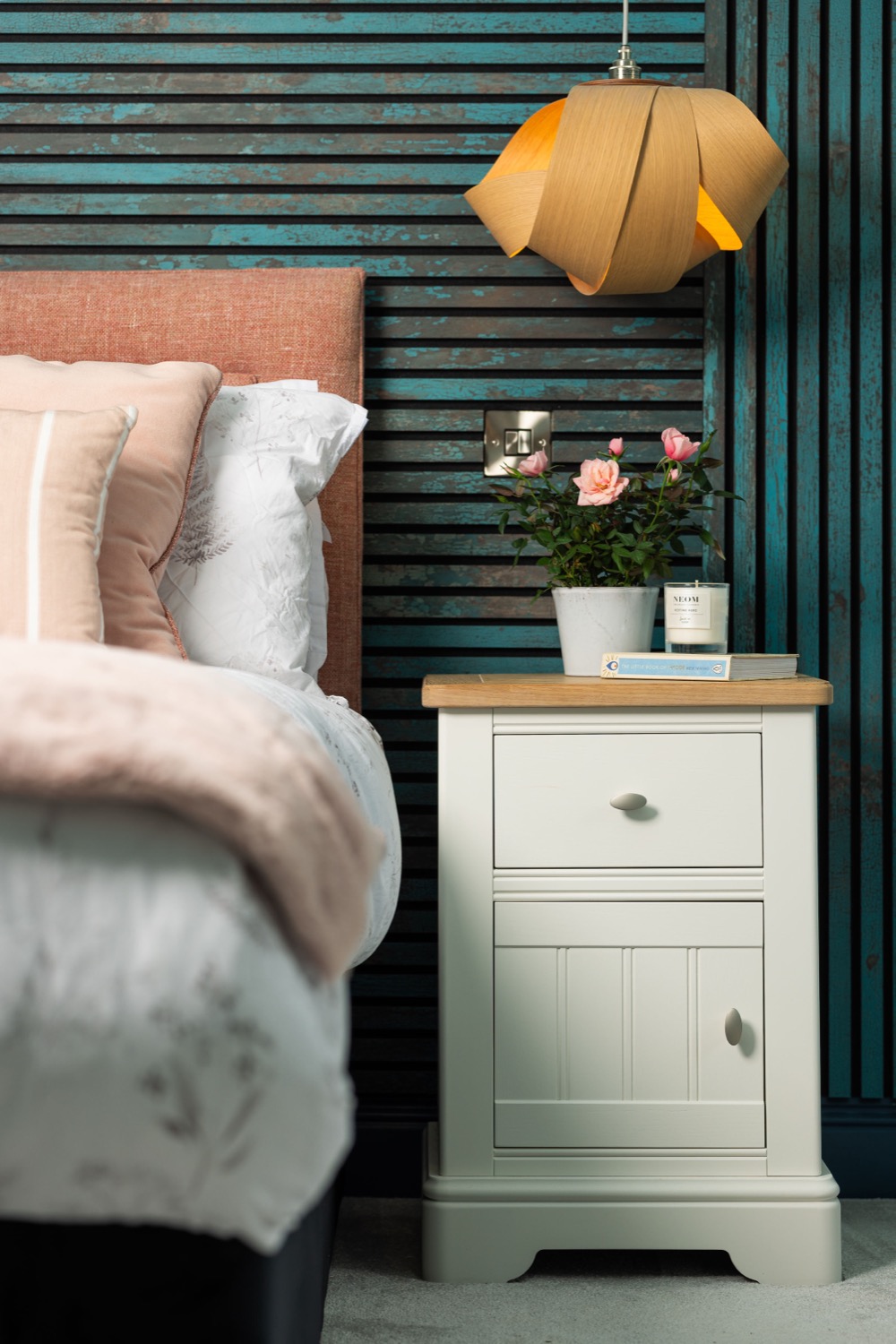 Bedroom bedside table with pendant lamp, pink roses and teal slatted wall panel in a contemporary interior design by Leisha Norman, interior photography