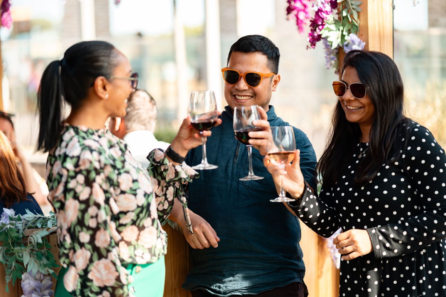 Friends toasting with wine glasses at an outdoor summer event, social lifestyle photography Southampton