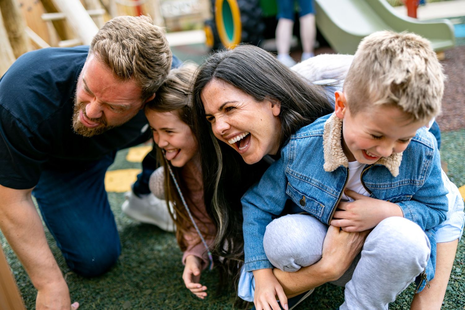Family laughing together at an outdoor playground, candid family lifestyle photography Southampton