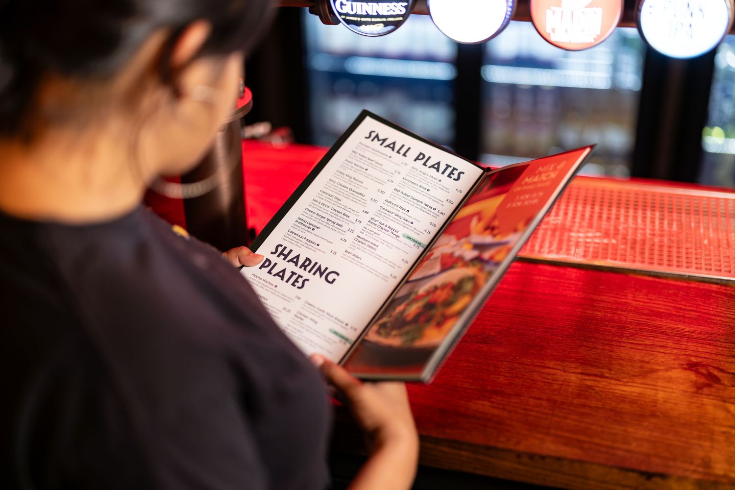 Woman reading a menu at the bar at Arrowsmiths Southampton, hospitality lifestyle photography