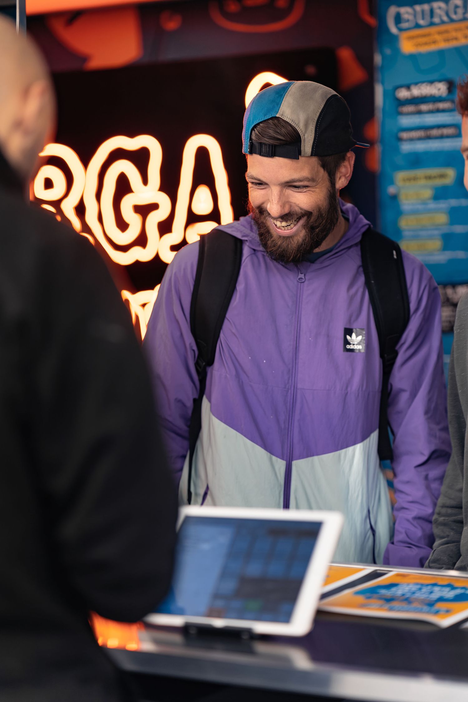 Customer smiling at the counter with Burga neon signage behind at Burga Portsmouth, hospitality lifestyle photography