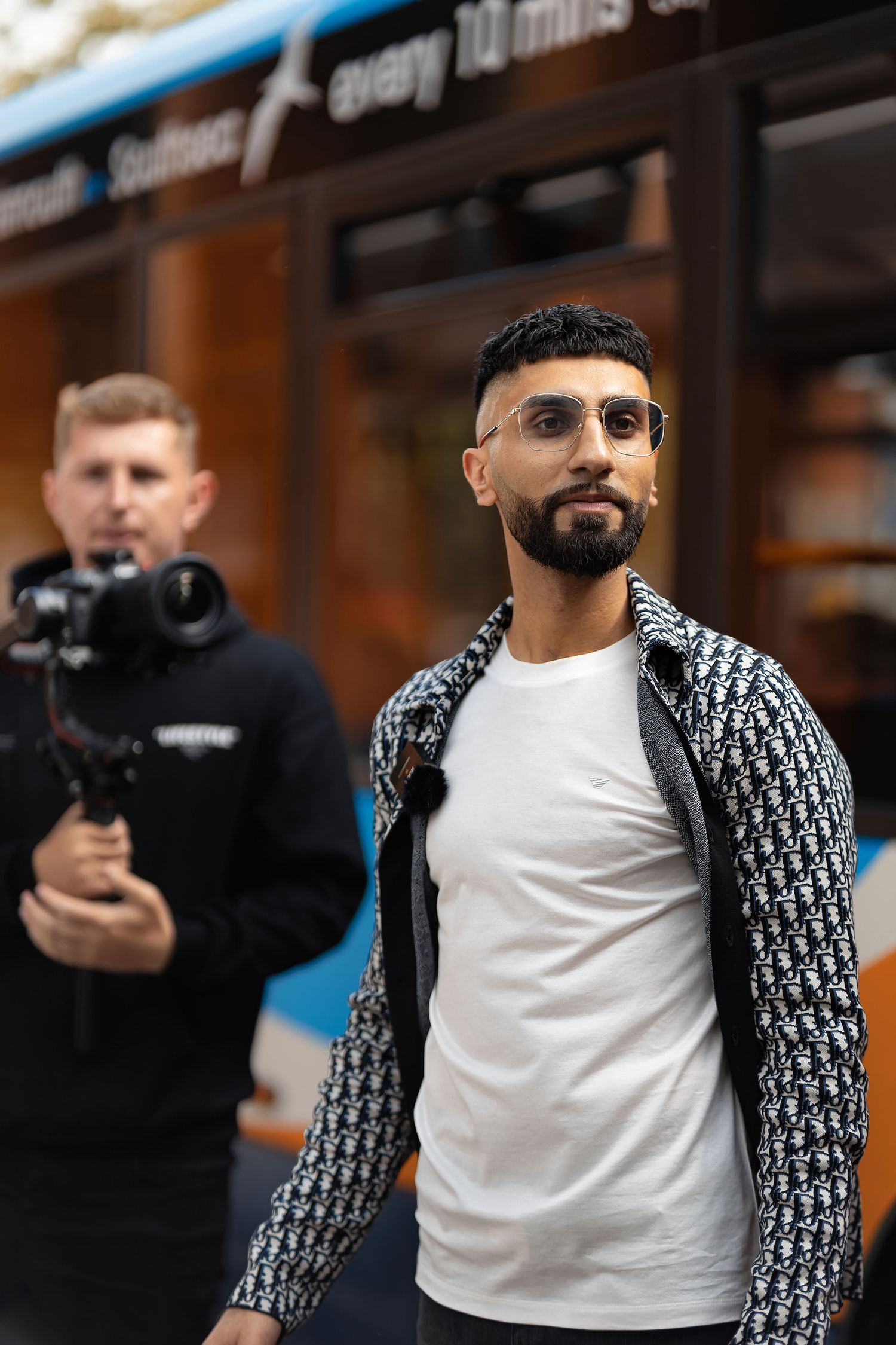 Man walking on the street with a videographer filming behind him in Portsmouth, behind the scenes lifestyle photography