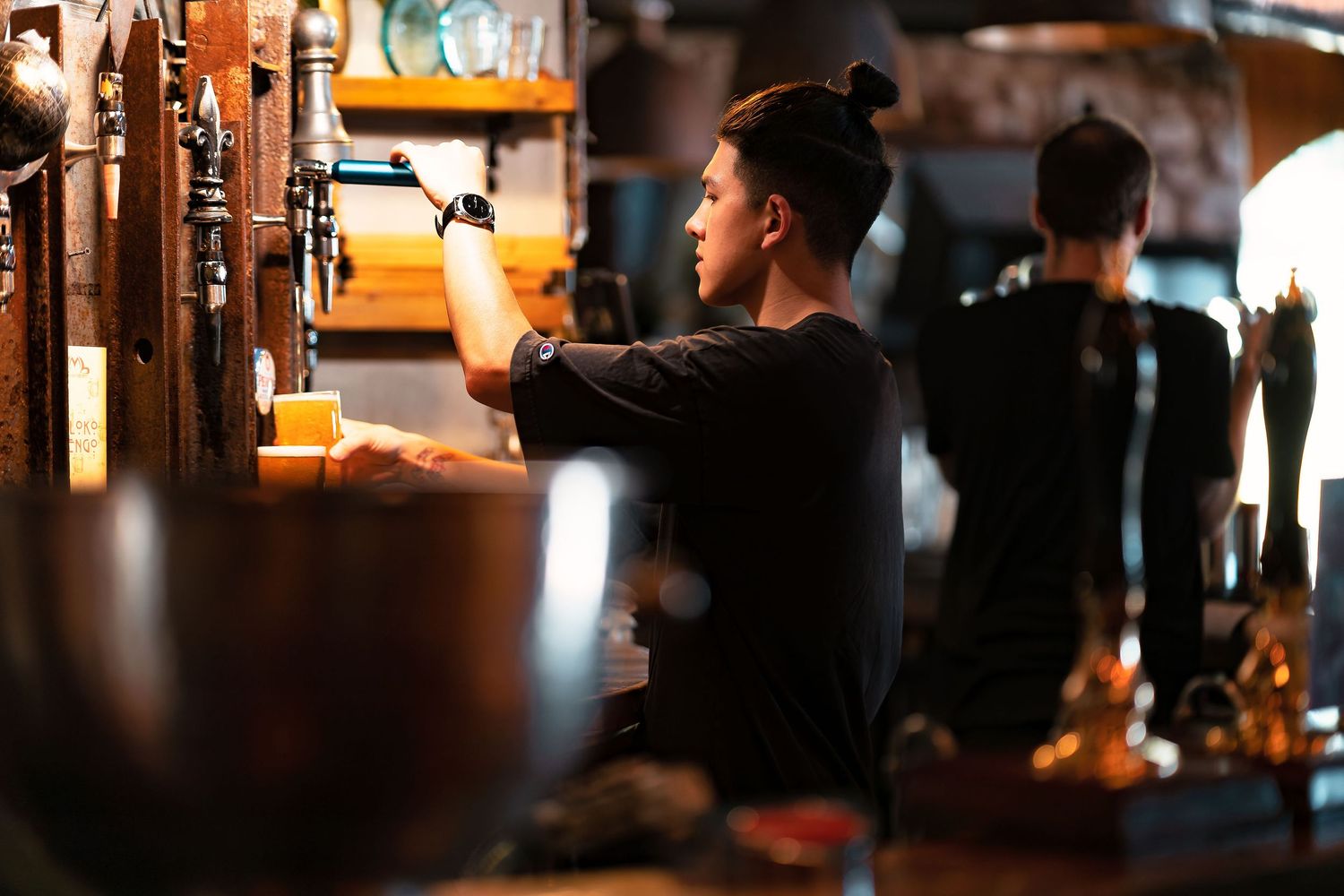 Bartender pulling a pint behind the bar at The Dancing Man brewery Southampton, hospitality lifestyle photography