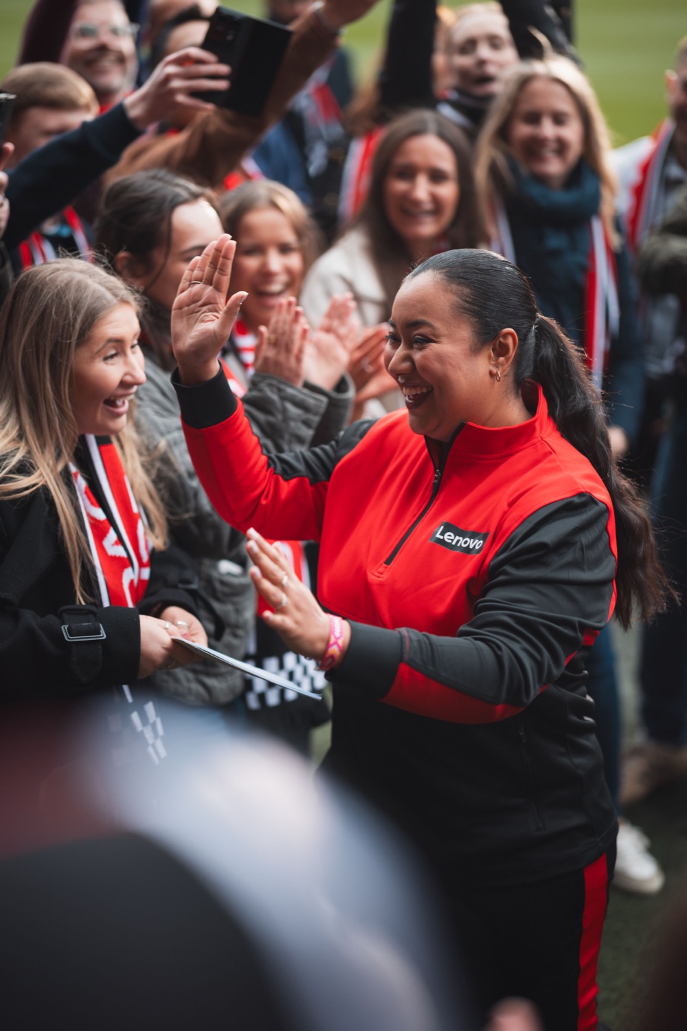 Lenovo brand ambassador high-fiving fans pitchside at St Marys Stadium Southampton, behind-the-scenes event documentary photography