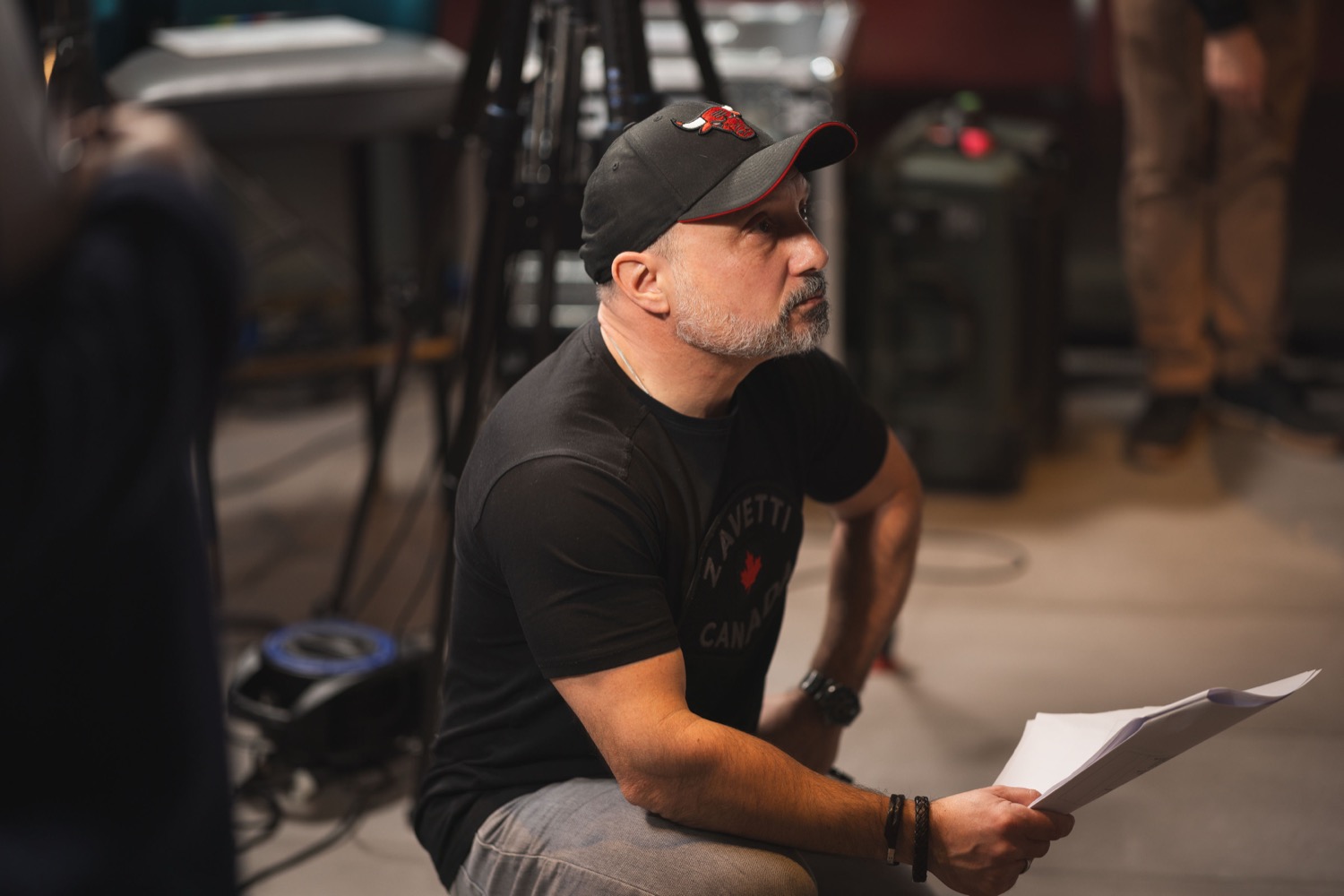Director reviewing script notes on set at St Marys Stadium Southampton during Lenovo filming, behind-the-scenes documentary photography