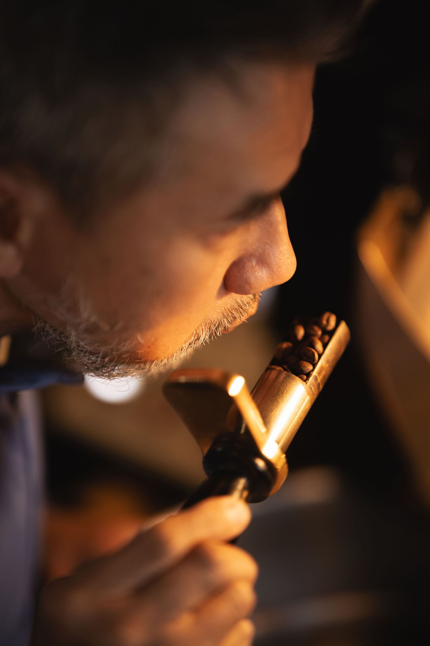 Close-up of a man smelling freshly roasted coffee beans from a sample scoop at Mettricks Portswood Southampton, artisan coffee lifestyle photography