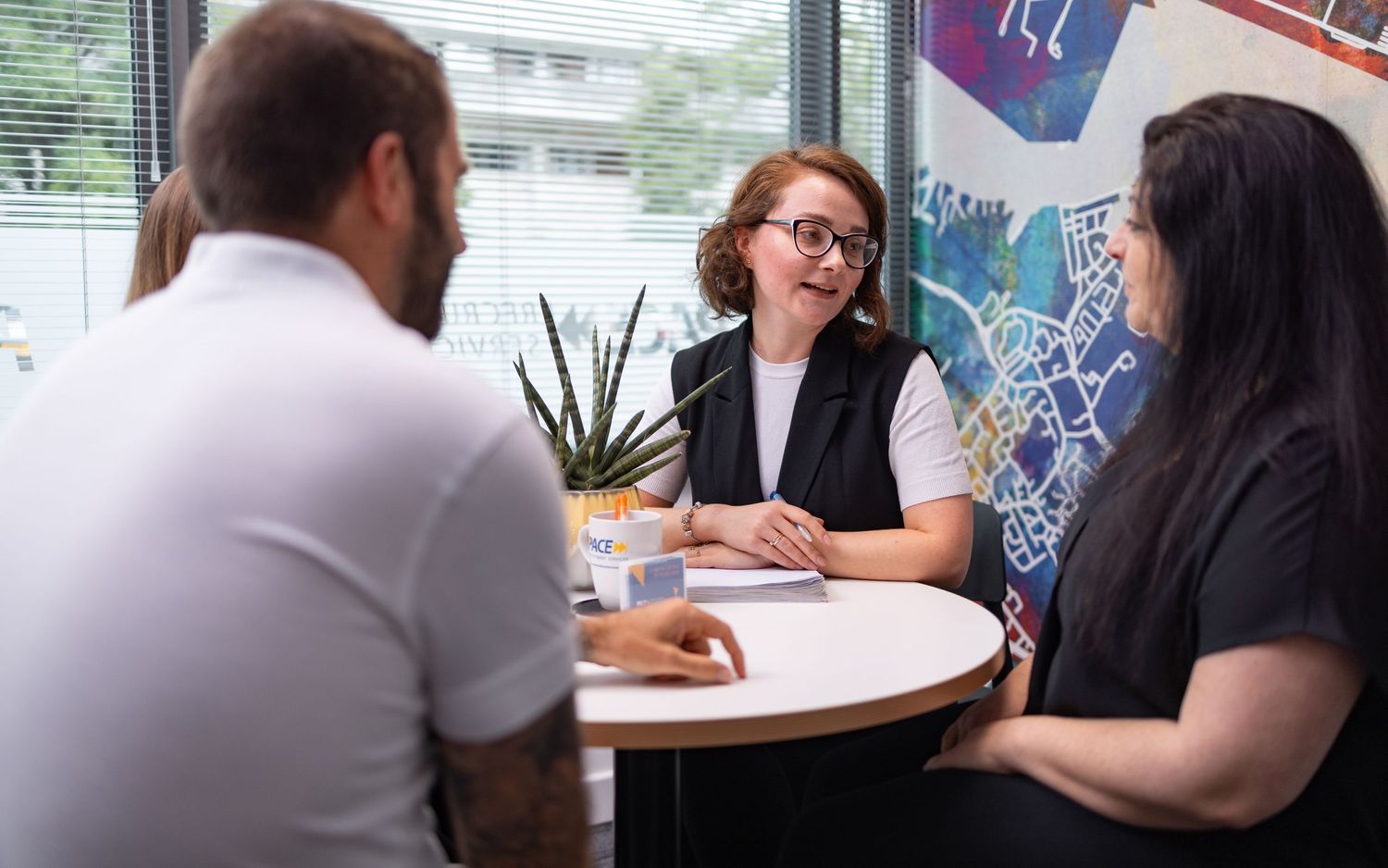 Colleagues in a meeting around a table at PACE offices Southampton, corporate lifestyle photography