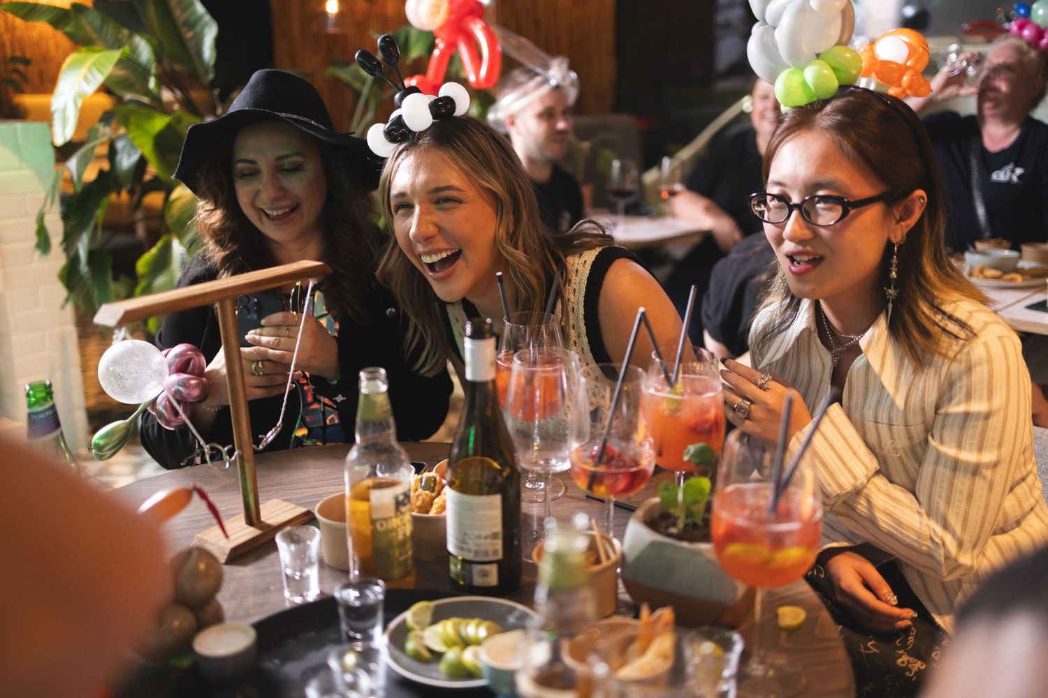 Guests laughing with cocktails and balloon decorations at a party event at Room2 Southampton, candid social lifestyle photography