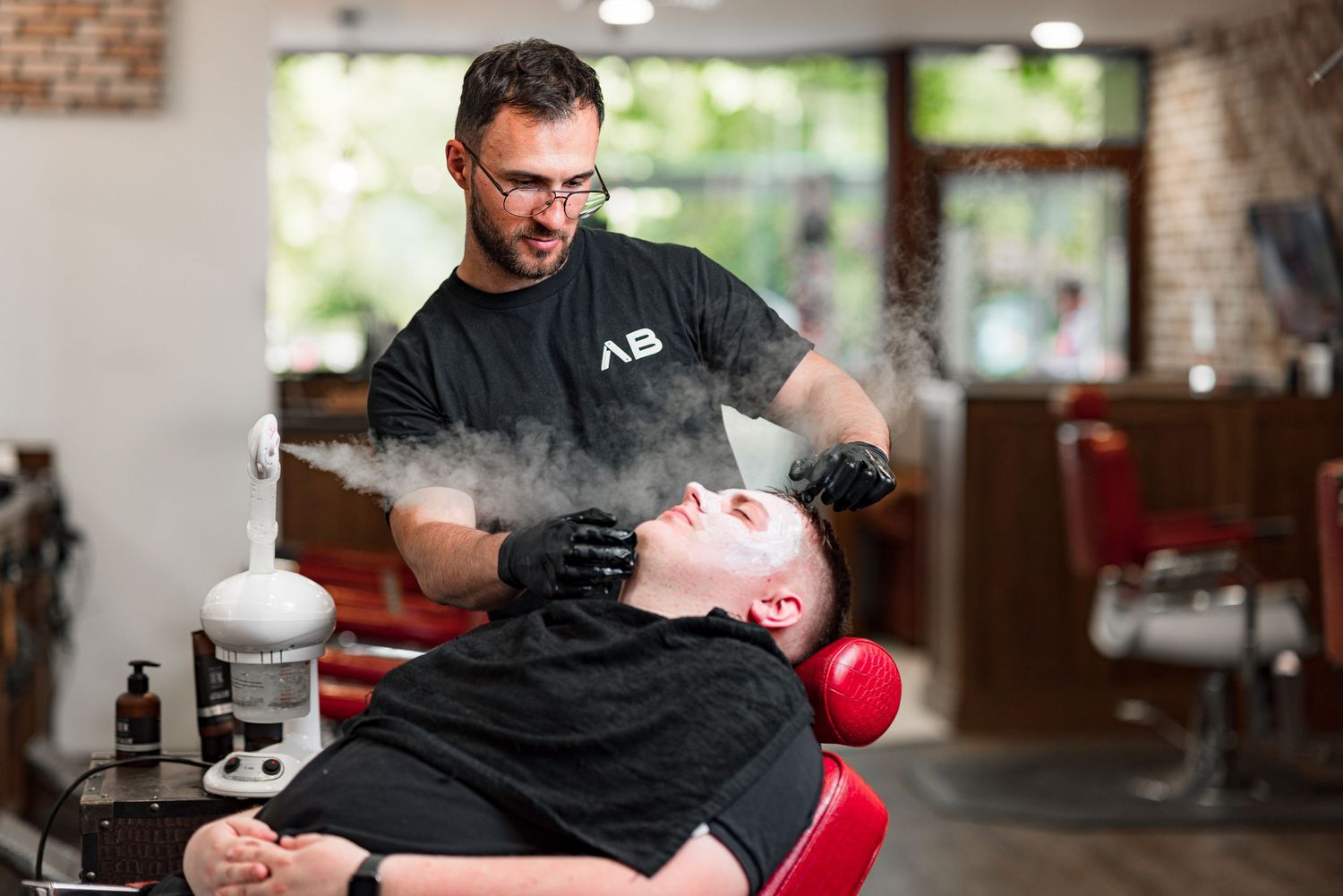 Barber applying steam treatment to a reclined client\