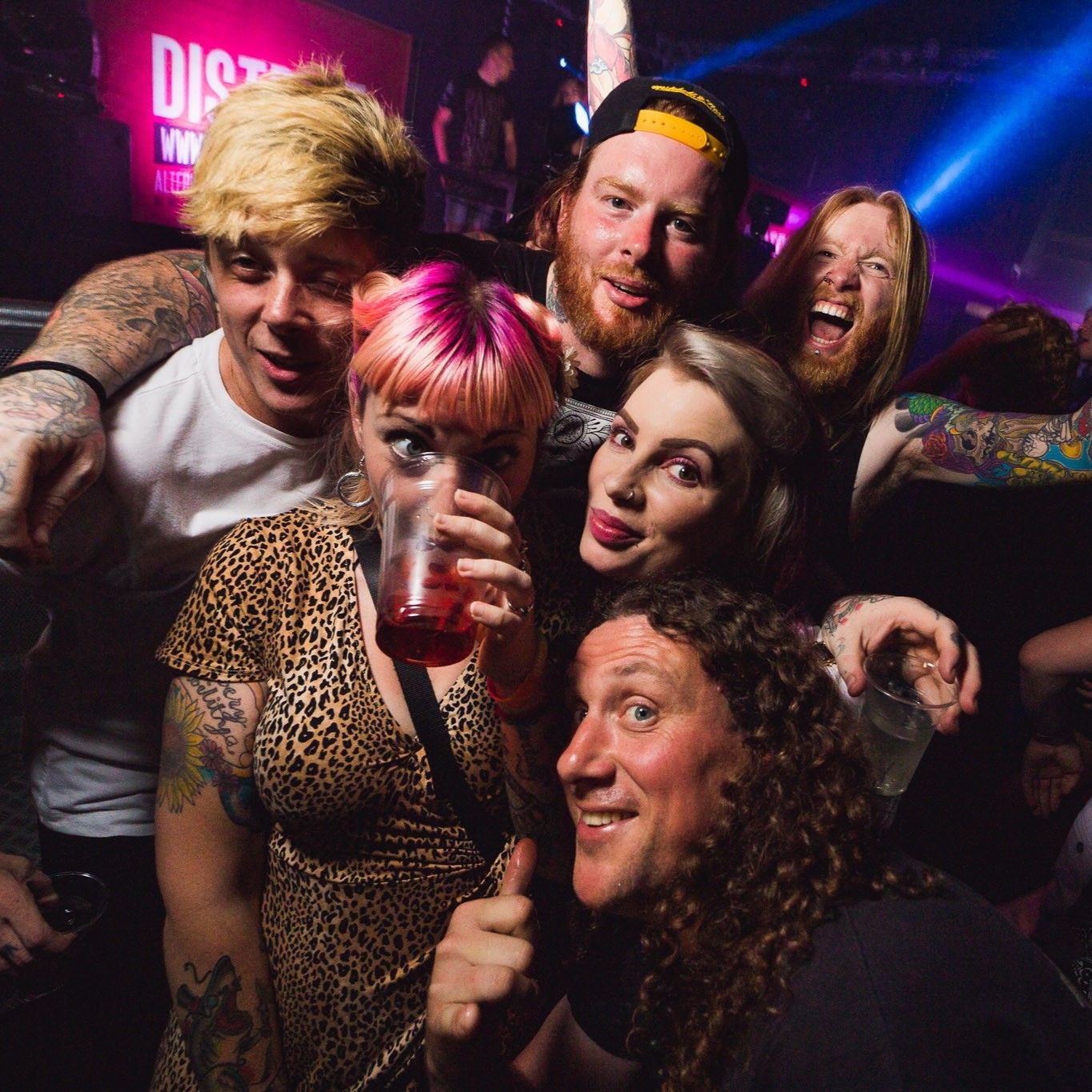 Group of friends enjoying a night out at District nightclub with pink and blue neon lighting, nightlife photography Southampton