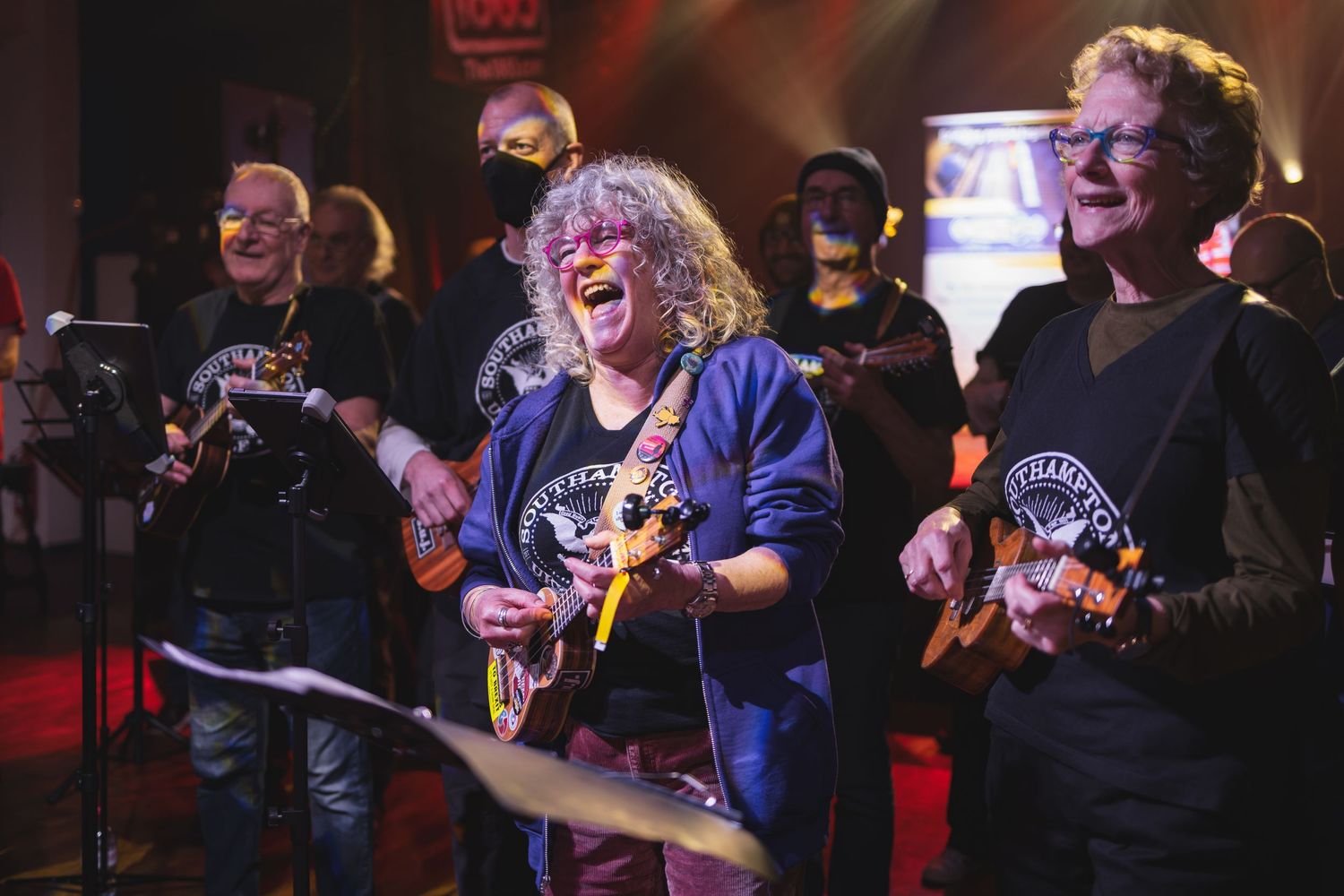 Southampton Ukuleles group performing together on stage at The 1865 with colourful lighting, live music event photography Southampton