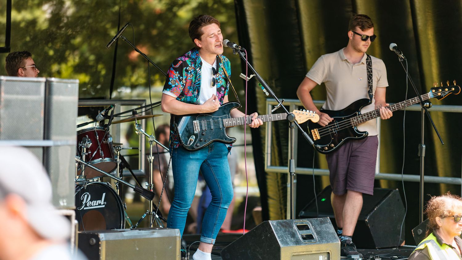 Band performing with singer-guitarist and bassist on an outdoor festival stage at Southampton Pride, live music event photography