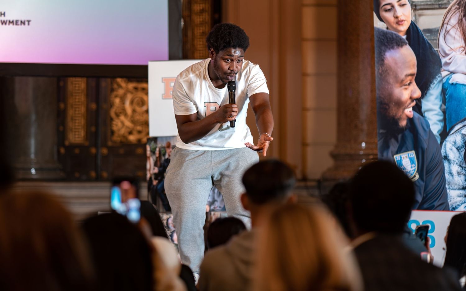Young speaker performing with a microphone to a seated audience at an indoor community event, live event photography Southampton