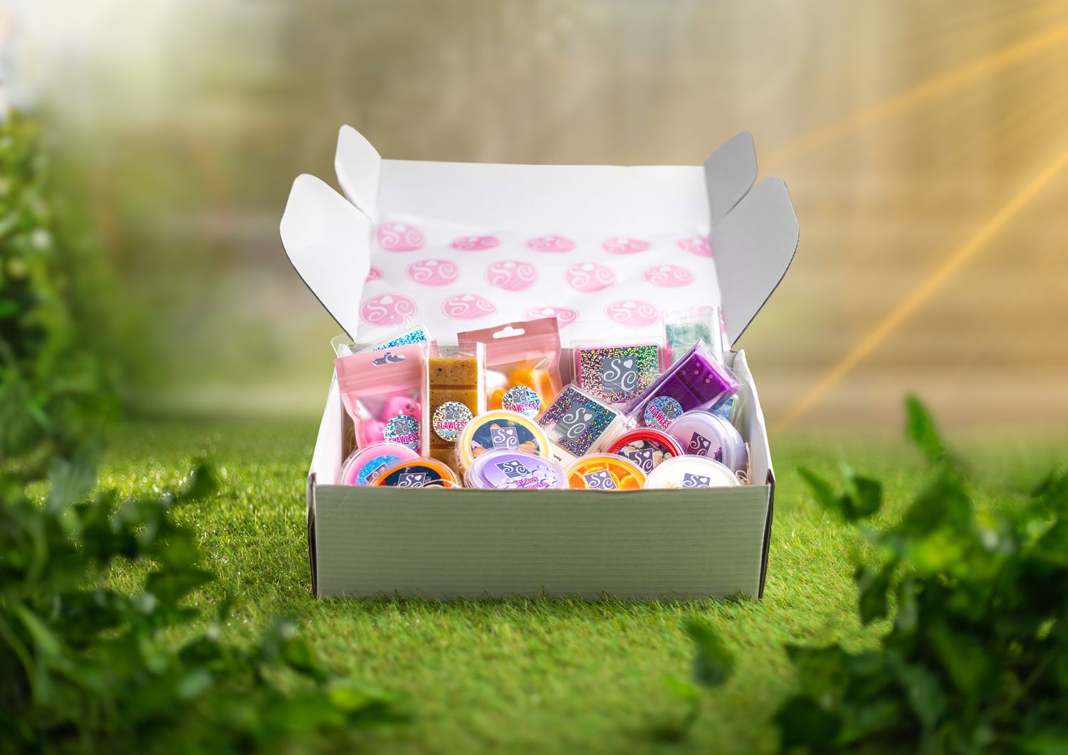 Open Shimmer Candles subscription box filled with wax melts and accessories on a grass surface with sunlight, packaging product photography Southampton