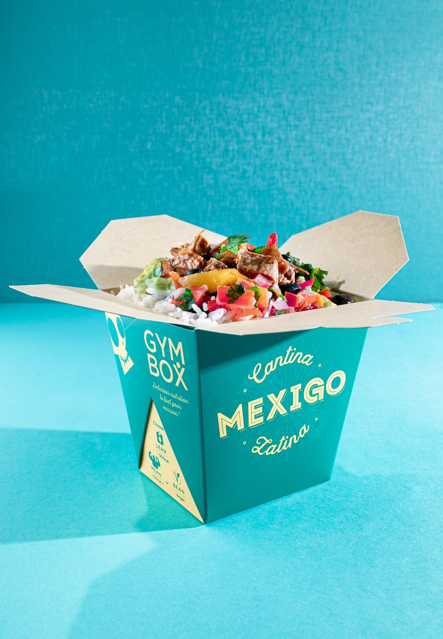 Gym Box branded Mexican food box filled with rice, salsa and grilled meat on a teal background, food packaging product photography Southampton