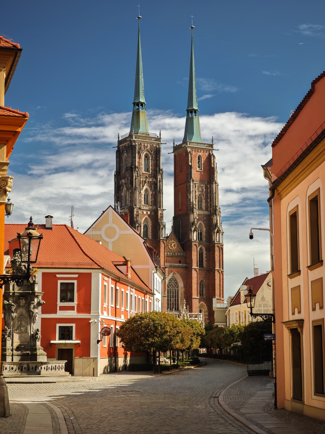 Twin cathedral spires rising above a quiet cobbled street, Wroclaw, Poland, travel photography