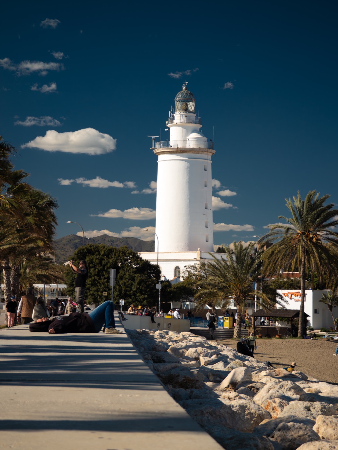 La Farola lighthouse at the end of a palm-lined promenade, Malaga, Spain, travel photography