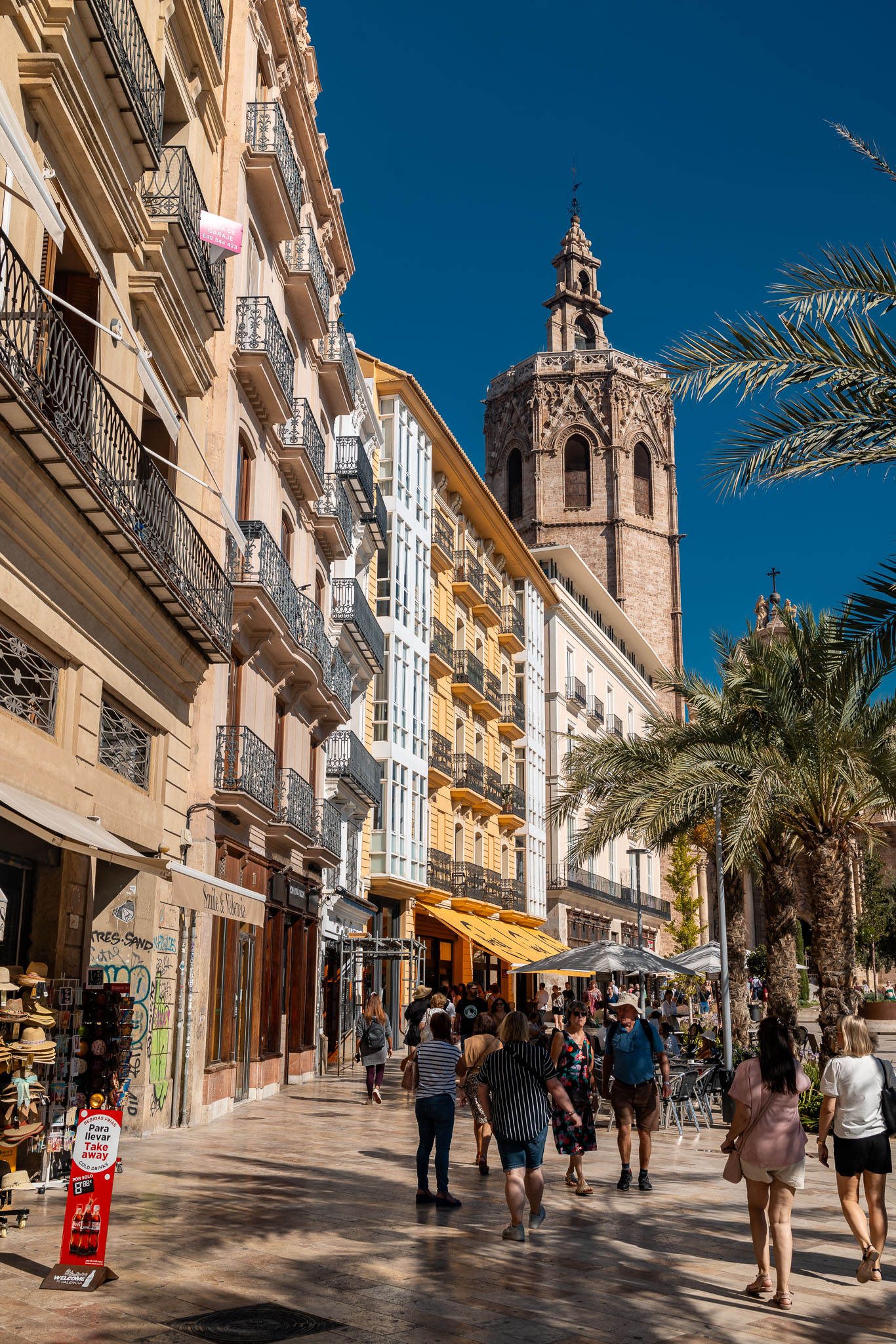 The Micalet bell tower above Plaza de la Reina with palms and pavement cafes, Valencia, Spain, travel photography