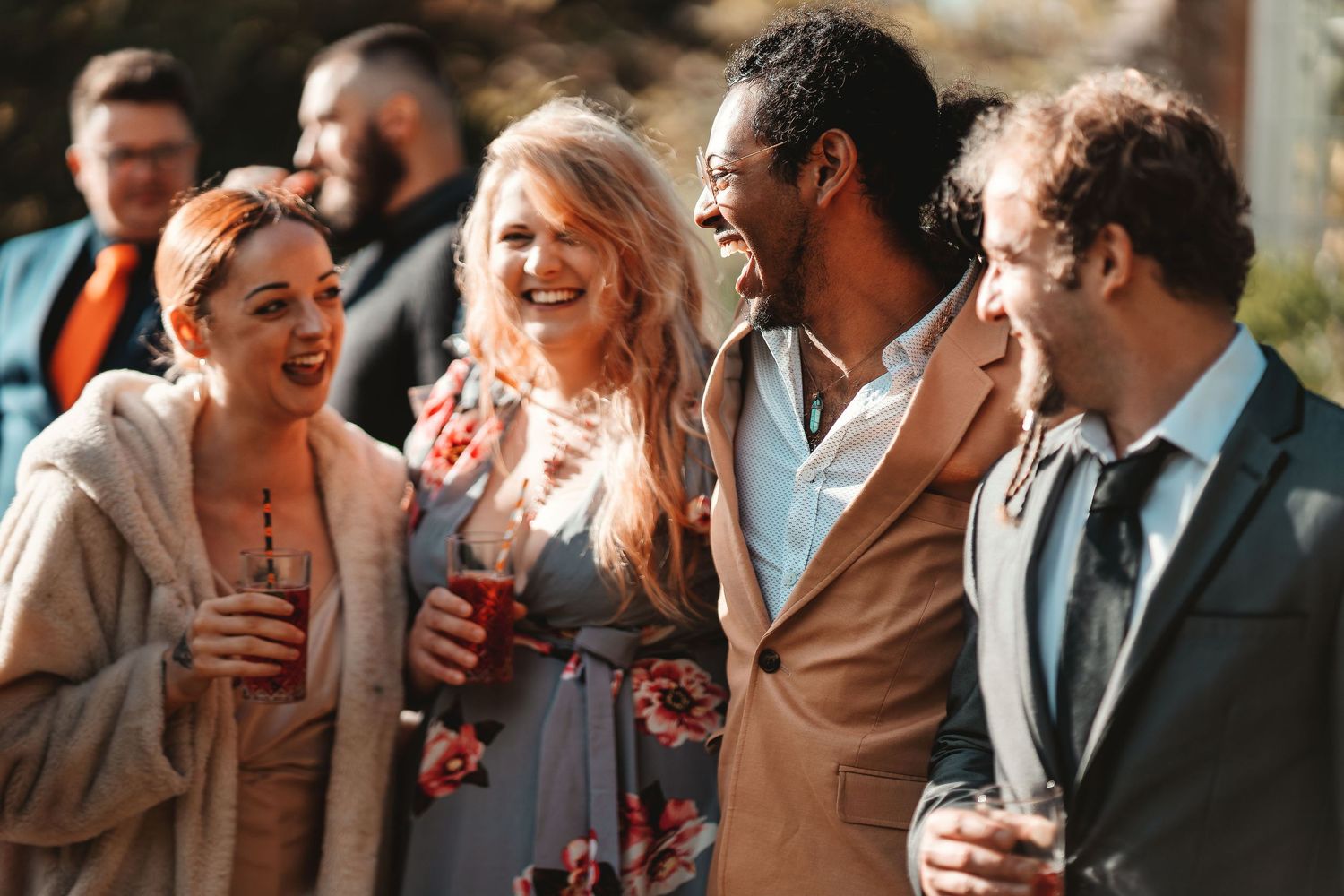 Wedding guests laughing and socialising outdoors at a reception, candid natural wedding photography St Audrie\